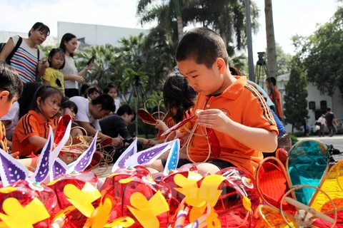 Các em thiếu nhi tập làm lồng đèn vui Tết Trung Thu tại Bảo tàng Dân tộc học Việt Nam. (Ảnh: Doãn Đức/ Vietnam+)