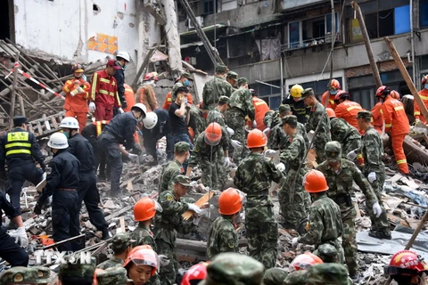 Nhân viên cứu hộ nỗ lực tìm kiếm nạn nhân vụ sập nhà tại quận Lộc Thành, thành phố Ôn Châu. (Nguồn: AFP/TTXVN)