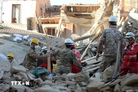 Lực lượng cứu hộ tìm kiếm nạn nhân động đất tại hiện trường đổ nát ở Amatrice, Italy ngày 26/8. (Nguồn: EPA/TTXVN)