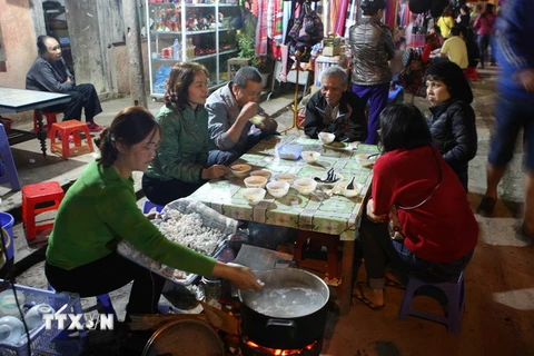 Du khách thưởng thức ẩm thực đêm tại chợ Đồng Văn. (Ảnh: Minh Quyết/TTXVN)
