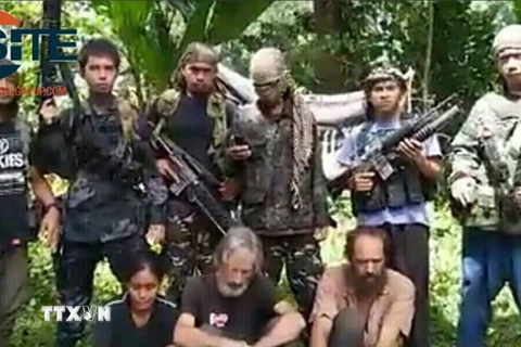 Phiến quân Abu Sayyaf và những con tin bị chúng bắt cóc. (Nguồn: TTXVN)