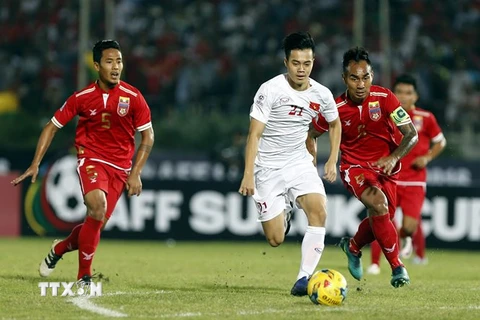 Tiền đạo Nguyễn Văn Toàn (giữa) đi bóng trước một hàng các cầu thủ Myanmar trong trận đấu. (Nguồn: EPA/TTXVN)