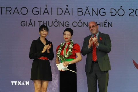 Ban tổ chức trao giải thưởng cá nhân có những đóng góp tích cực trong hỗ trợ những người trong Mạng lưới người sống chung với HIV Việt Nam. (Ảnh: Phương Vy/TTXVN)