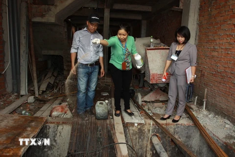 Cán bộ y tế phường Phú Thạnh, quận Tân Phú rải thuốc diệt loăng quăng tại một công trình xây dựng. (Ảnh: Phương Vy/TTXVN)