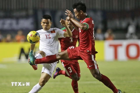 Pha tranh bóng giữa Lê Văn Thắng (trái) và cầu thủ Indonesia Stefano Lilipaly Bayu Pradana Andriatmoko (phải) trong trận đấu bán kết lượt đi. (Nguồn: AP/TTXVN)