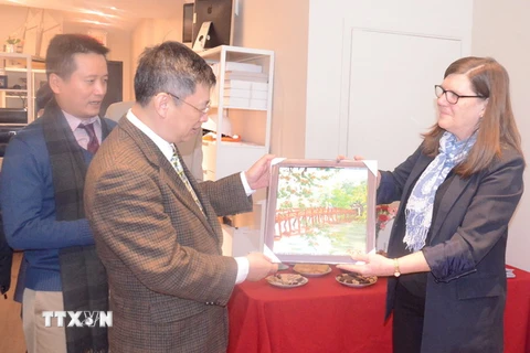 Ông Nguyễn Tuấn Phong tặng bà Sandra Smith và Đảng Cộng sản Marxist Leninist Canada bức tranh về Hà Nội. (Ảnh: Trường Giang/TTXVN)