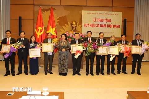 Chủ tịch Quốc hội Nguyễn Thị Kim Ngân dự và trao Huy hiệu 30 năm tuổi Đảng cho các Đảng viên. (Ảnh: Trọng Đức/TTXVN)