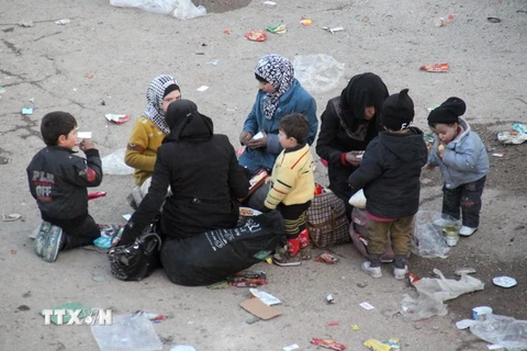 Những người phụ nữ Syria đưa con cái đi sơ tán tới khu vực Khan al-Assal, phía tây Aleppo. (Nguồn: AP/TTXVN)