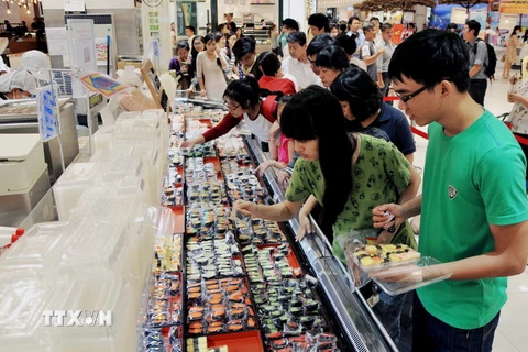 Người tiêu dùng TP Hồ Chí Minh chọn mua thức ăn truyền thống sushi Nhật Bản tại khu ẩm thực của Trung tâm mua sắm Aeon Mall. (Ảnh: An Hiếu/TTXVN)