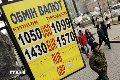 Người dân đi bên ngoài một ngân hàng ở trung tâm thủ đô Kiev. (Nguồn: AFP/TTXVN)