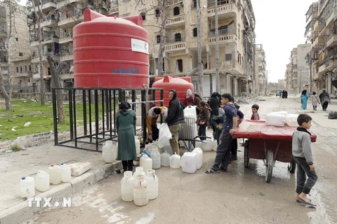 Người dân xếp hàng lấy nước sạch ở thành phố Aleppo, miền bắc Syria ngày 9/3. (Nguồn: AFP/TTXVN)