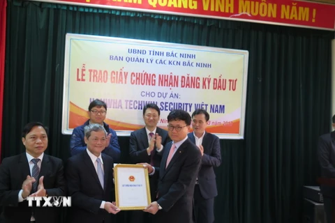 Chủ tịch UBND tỉnh Bắc Ninh trao giấy chứng nhận đầu tư 100 triệu USD cho đại diện Công ty Hanwha Techwin Security Hàn Quốc. (Ảnh: Thái Hùng/TTXVN)