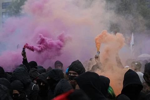 Người biểu tình trùm đầu dùng bom khói tại Kreuzberg, Đức. (Nguồn: AFP)