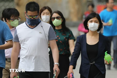 Người dân đeo khẩu trang tránh khói bụi bao phủ thủ đô Bắc Kinh ngày 4/5. (Nguồn: EPA/TTXVN)