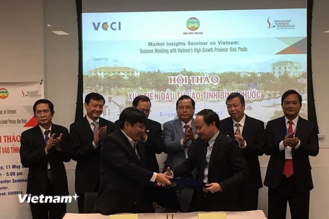 Đại diện tỉnh Bình Phước ký kết Biên bản Ghi nhớ với Hiệp Hội Thương mại Việt Nam tại Singapore. (Ảnh: Mỹ Bình/Vietnam+)