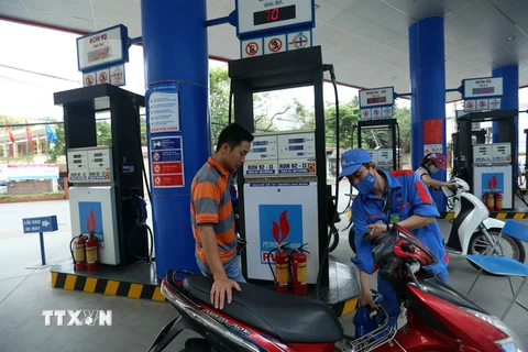 Khách hàng mua xăng tại Cửa hàng xăng dầu của PV OIL Hà Nội. (Ảnh: Huy Hùng/TTXVN)
