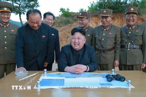  Nhà lãnh đạo Triều Tiên Kim Jong-un (giữa, phía trước) giám sát vụ phóng thử tên lửa đạn đạo đất đối đất kiểu mới Hwasong-12 ngày 14/5. (Nguồn: YONHAP/TTXVN)