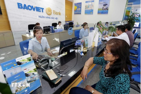 Khách hàng giao dịch tại BAOVIETBank chi nhánh Bình Dương. (Ảnh: Trần Việt/TTXVN)
