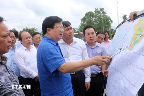 Phó Thủ tướng Trịnh Đình Dũng kiểm tra khảo sát khu vực vị trí xây dựng cầu Đại Ngãi bắc qua sông Hậu. (Ảnh: Trung Hiếu/TTXVN)