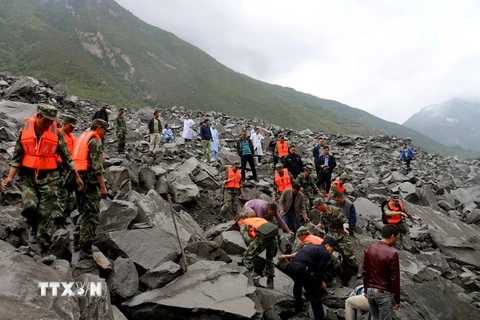 Nhân viên cứu hộ nỗ lực tìm kiếm người mất tích trong vụ lở đất. (Nguồn: AFP/TTXVN)