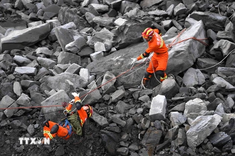  Lực lượng cứu hộ tìm kiếm những người mắc kẹt sau vụ lở đất ở huyện Mậu, Tứ Xuyên ngày 25/6. (Nguồn: THX/TTXVN)