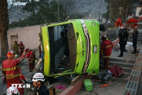 Lực lượng cứu hộ làm nhiệm vụ tại hiện trường vụ tai nạn xe buýt hai tầng ở quận Rimac ngày 9/7. (Nguồn: EPA/TTXVN)