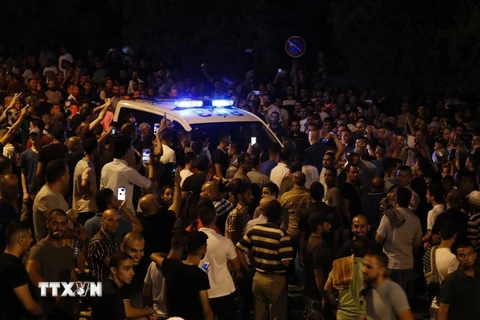Người Palestine phong tỏa xe của cảnh sát Israel bên ngoài cổng Lion, một lối vào đền thờ Hồi giáo Al-Aqsa ngày 22/7. (Nguồn: AFP/TTXVN)