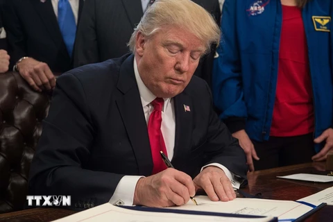 Tổng thống Mỹ Donald Trump ký ban hành một đạo luật tại Nhà Trắng ngày 21/3. (Nguồn: AFP/TTXVN)