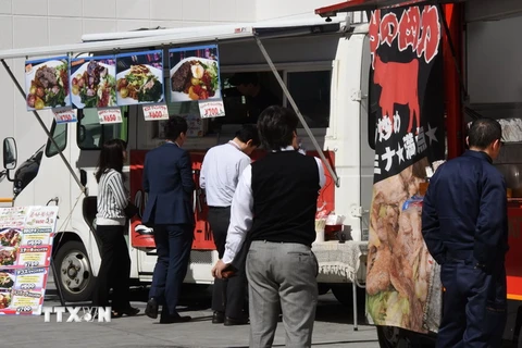  Người dân Nhật Bản mua đồ ăn trưa trên một đường phố ở Tokyo. (Nguồn: AFP/TTXVN)