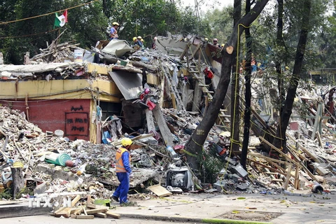  Lực lượng cứu hộ dọn dẹp hiện trường đổ nát sau động đất ở Mexico City, Mexico ngày 26/9. (Nguồn: THX/TTXVN)