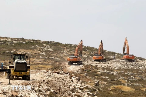 Các công nhân Israel sử dụng máy xúc mở đường, chuẩn bị cho việc xây dựng khu định cư Amichai ở Bờ Tây ngày 21/6. (Nguồn: EPA/TTXVN)