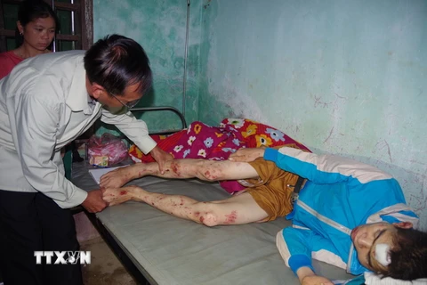 Bác sỹ khám cho nạn nhân Hà Văn Luôn bị thương tích do lũ gây ra. (Ảnh: Nhan Sinh/TTXVN)