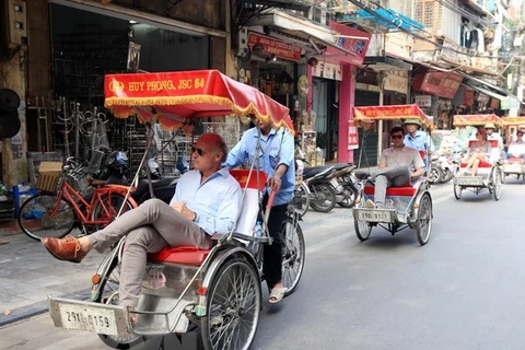 Du khách quốc tế thăm Hà Nội bằng xíchlô. (Ảnh: Anh Tuấn/TTXVN)