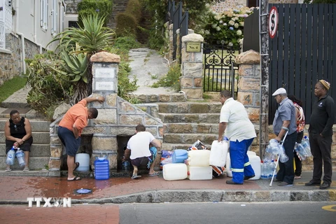 Người dân xếp hàng chờ lấy nước sinh hoạt tại một vòi nước công cộng ở Cape Town ngày 19/1. (Nguồn: AFP/TTXVN)
