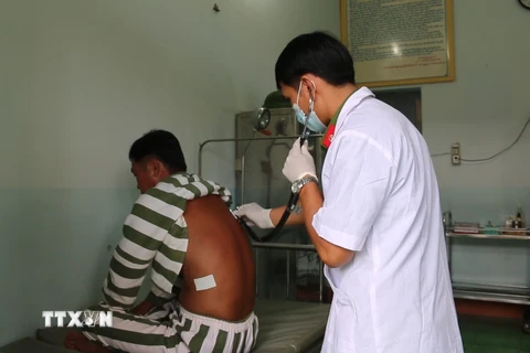Thiếu tá-y sĩ Lê Mạnh Phước thăm khám cho bệnh nhân, phạm nhân trong trại giam. (Ảnh: Sỹ Tuyên/TTXVN)