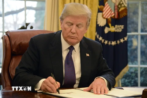 Tổng thống Mỹ Donald Trump ký một sắc lệnh tại Nhà Trắng ngày 23/1. (Nguồn: UPI-YONHAP/TTXVN)