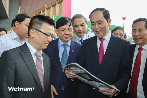 Chủ tịch nước Trần Đại Quang xem một ấn phẩm của TTXVN. (Ảnh: Lê Minh Sơn/Vietnam+)