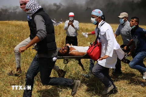 Chuyển người Palestine bị thương trong xung đột với binh sỹ Israel ở khu vực biên giới giữa Israel với Dải Gaza ngày 6/4. (Nguồn: THX/TTXVN)