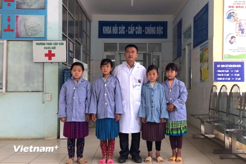 Trưởng khoa Hồi sức-Cấp cứu-Chống độc, Bệnh viện Đa khoa huyện Mèo Vạc chụp ảnh với 4 cháu học sinh sáng 13/4 trước khi 3 cháu được xuất viện. (Ảnh: Minh Tâm/TTXVN)