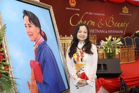 Đại sứ Luận Thùy Dương bên bức tranh cua rmột họa sỹ Myanmả vẽ chân dung bà Cố vấn Nhà nước Aung San Suu Kyi tại Triển lãm nghệ thuật "Việt Nam-Myanmar: Duyên dáng và xinh đẹp" tổ chức tại Yangon trong tháng 5/2017.