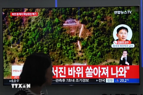 Người dân theo dõi hình ảnh được phát qua truyền hình Hàn Quốc về lễ dỡ bỏ bãi thử hạt nhân Punggye-ri của Triều Tiên, tại nhà ga Seoul (Hàn Quốc) ngày 24/5. (Nguồn: AFP/TTXVN)