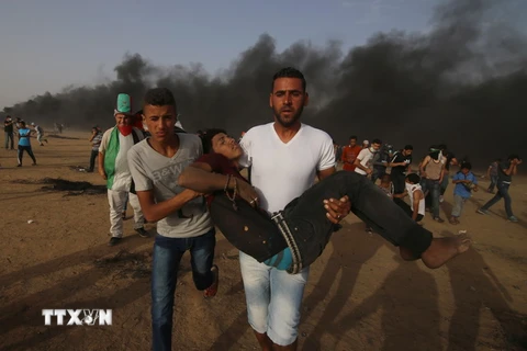 Chuyển nạn nhân bị thương trong cuộc xung đột giữa người biểu tình Palestine và binh sĩ Israel tại biên giới Gaza-Israel ngày 25/5. (Nguồn: THX/TTXVN)
