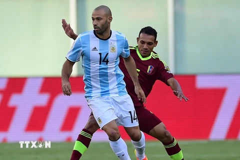 Pha tranh bóng giữa cầu thủ Arquimedes Figuera (phía sau) của Venezuela và Javier Mascherano của Argentina trong một trận đấu năm 2016. (Nguồn: AFP/TTXVN)