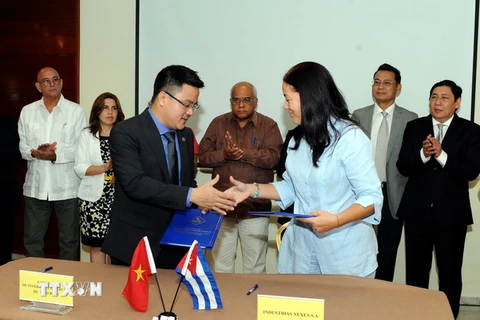 Tổng Giám đốc công ty Thái Bình, Trần Ngọc Thuận, và Chủ tịch tập đoàn Industrias Nexus, Magaly Calvo Mira, trao đổi thỏa thuận đẩy mạnh dự án chất tẩy rửa tại Đặc khu Mariel. (Ảnh: Lê Vũ Hà/TTXVN)