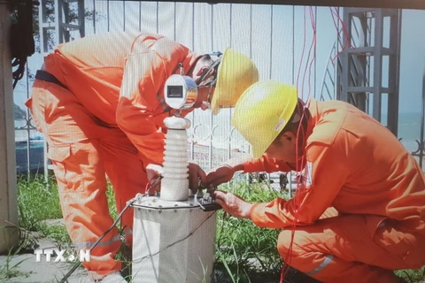Công nhân Công ty Điện lực Quảng Ninh khắc phục sự cố sét đánh hỏng đường dây truyền tải điện 22kV khiến toàn bộ đảo huyện đảo Cô Tô mất điện. (Ảnh: Văn Đức/TTXVN)