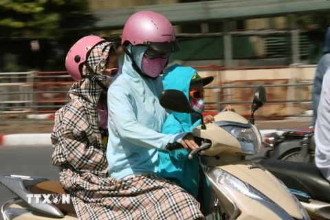Người dân Hà Nội tham gia giao thông dưới nắng nóng. (Ảnh: Doãn Tấn/TTXVN)