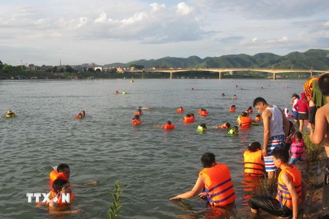 Việc người dân kéo nhau ra sông Đà tắm, bơi lội khá nguy hiểm. (Ảnh: Thanh Hải/TTXVN)