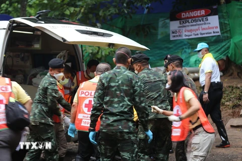  Lực lượng cứu hộ chuyển thành viên đội bóng lên xe cứu thương sau khi được cứu khỏi hang Tham Luang. (Ảnh: THX/TTXVN)