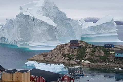 Một tảng băng trôi khổng lồ được nhìn thấy đằng sau khu định cư trên đảo Innaarsuit, Greenland ngày 12/7. (Nguồn: Reuters)
