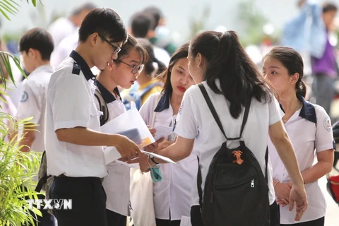 Các thí sinh trao đổi sau khi hoàn tất phần thi môn Toán tại Hội đồng thi trường THCS Collette, quận 3. TP. Hồ Chí Minh. (Ảnh: Quang Nhựt - TTXVN)